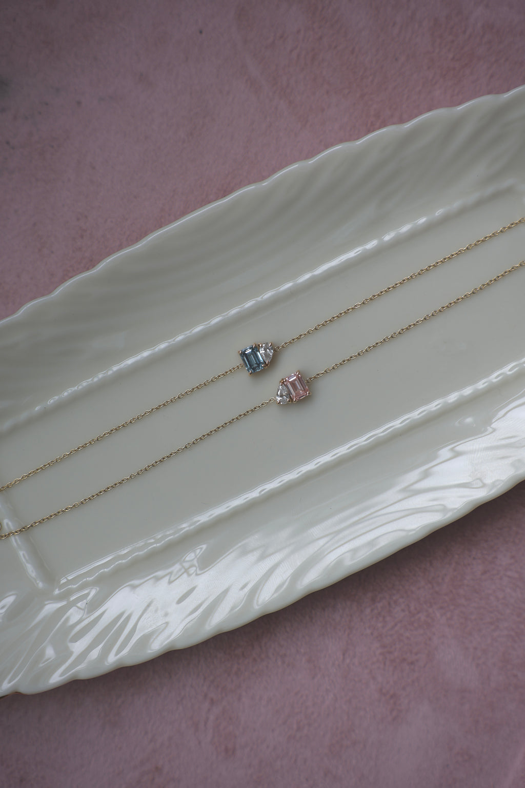Blue and pink Toi et Moi lab diamond bracelets in solid 14k gold displayed on a jewelry tray